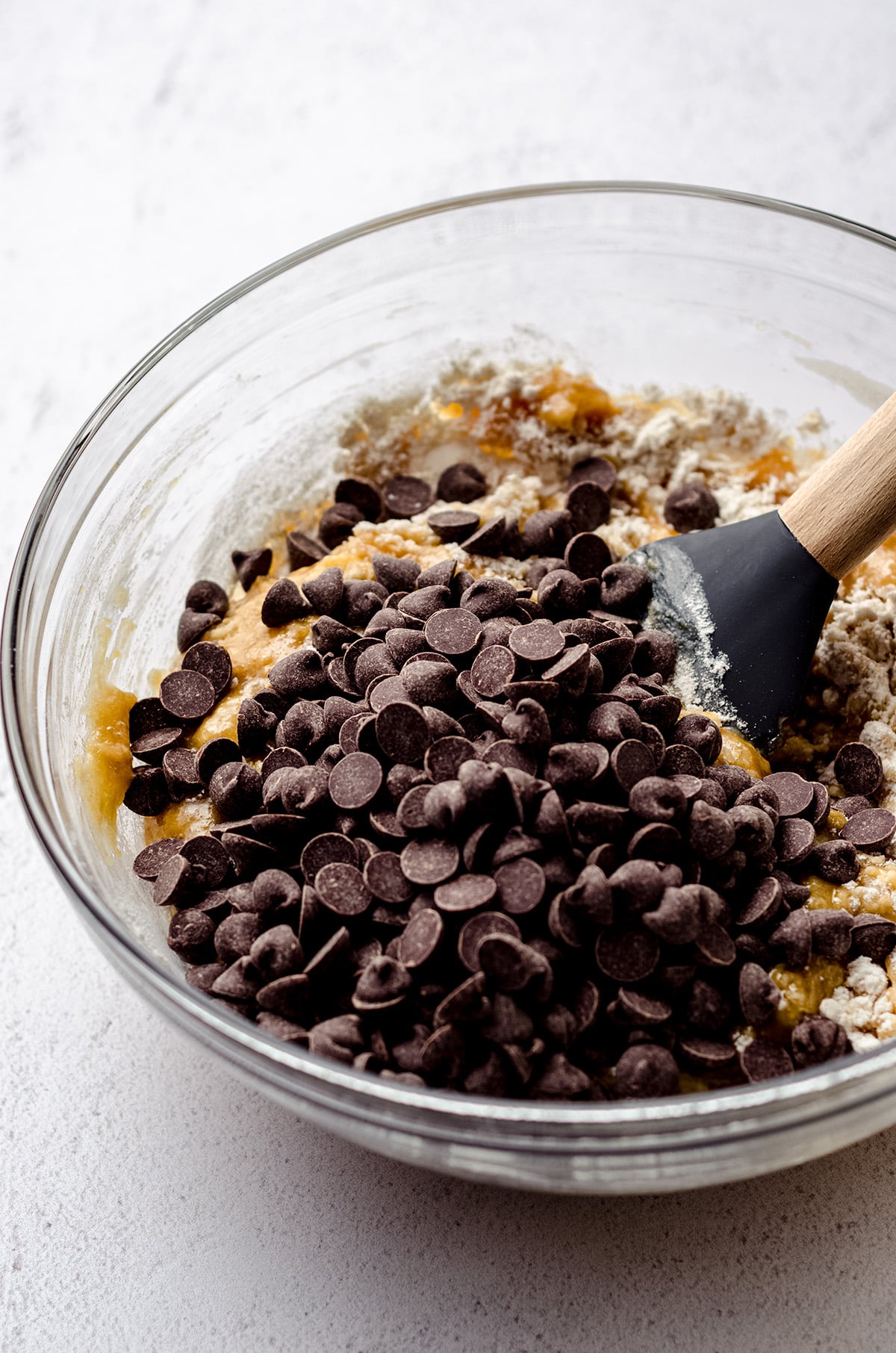 chocolate chips in chocolate chip cookie cake batter in a bowl
