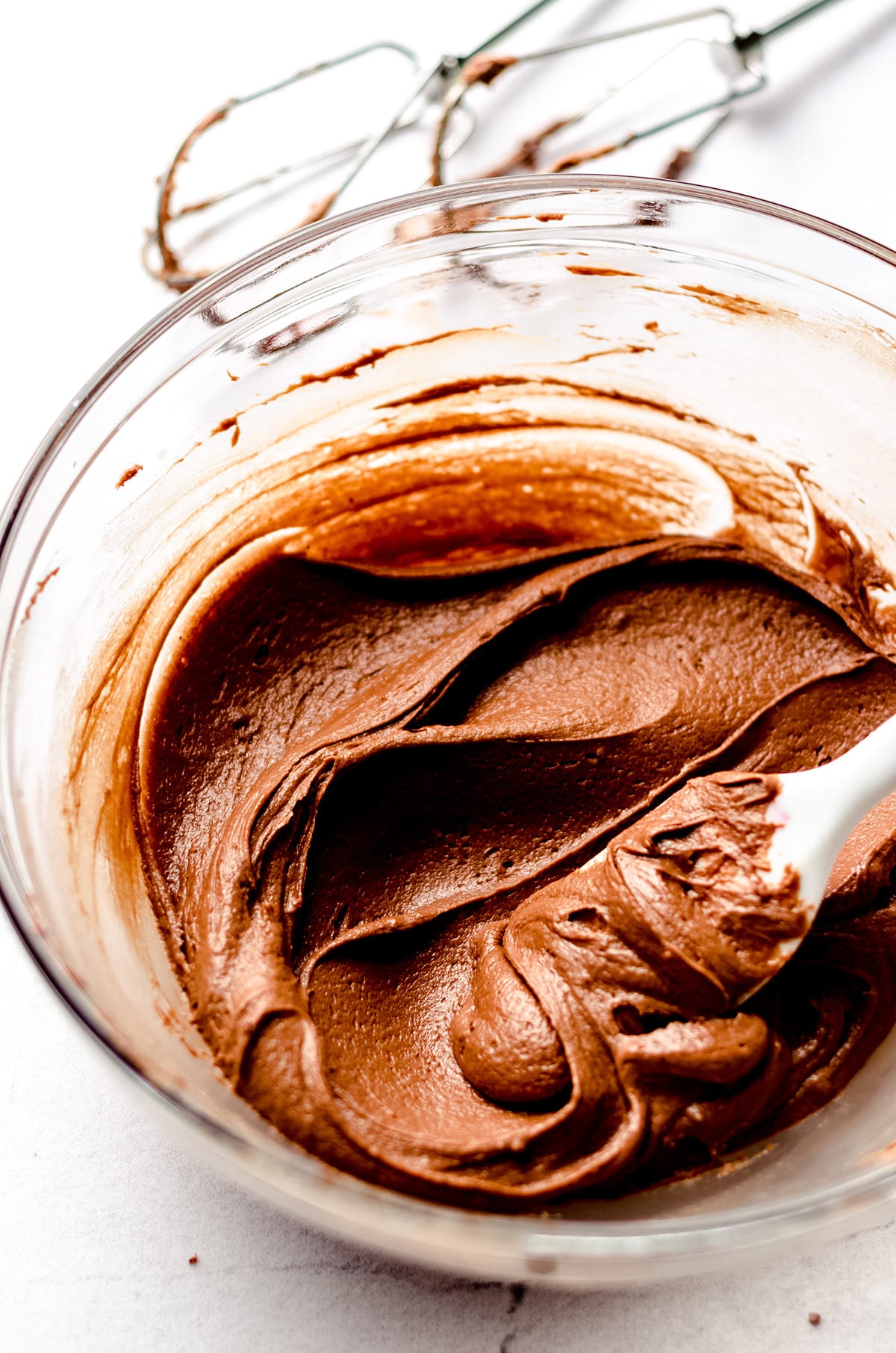 chocolate cookie cake icing in a bowl with a spatula