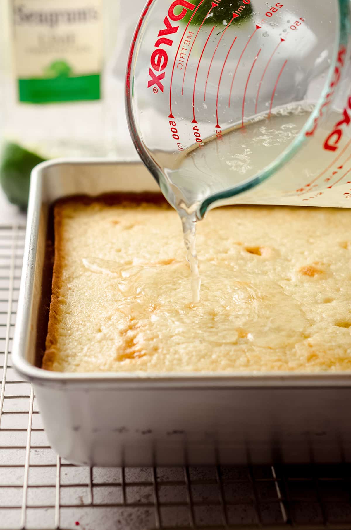 pouring gin and tonic syrup onto gin and tonic cake