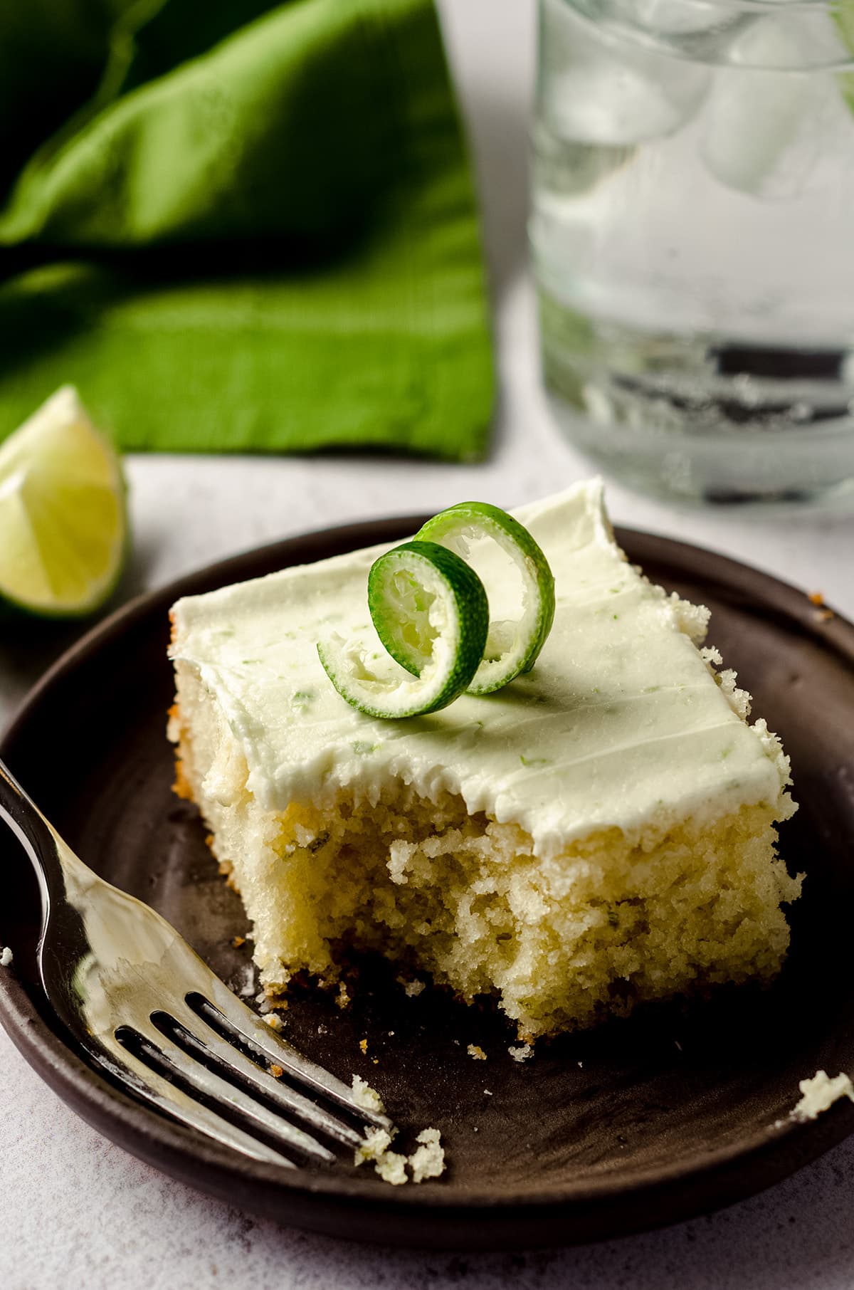 gin and tonic cake on a plate with a fork and a bite taken out of it