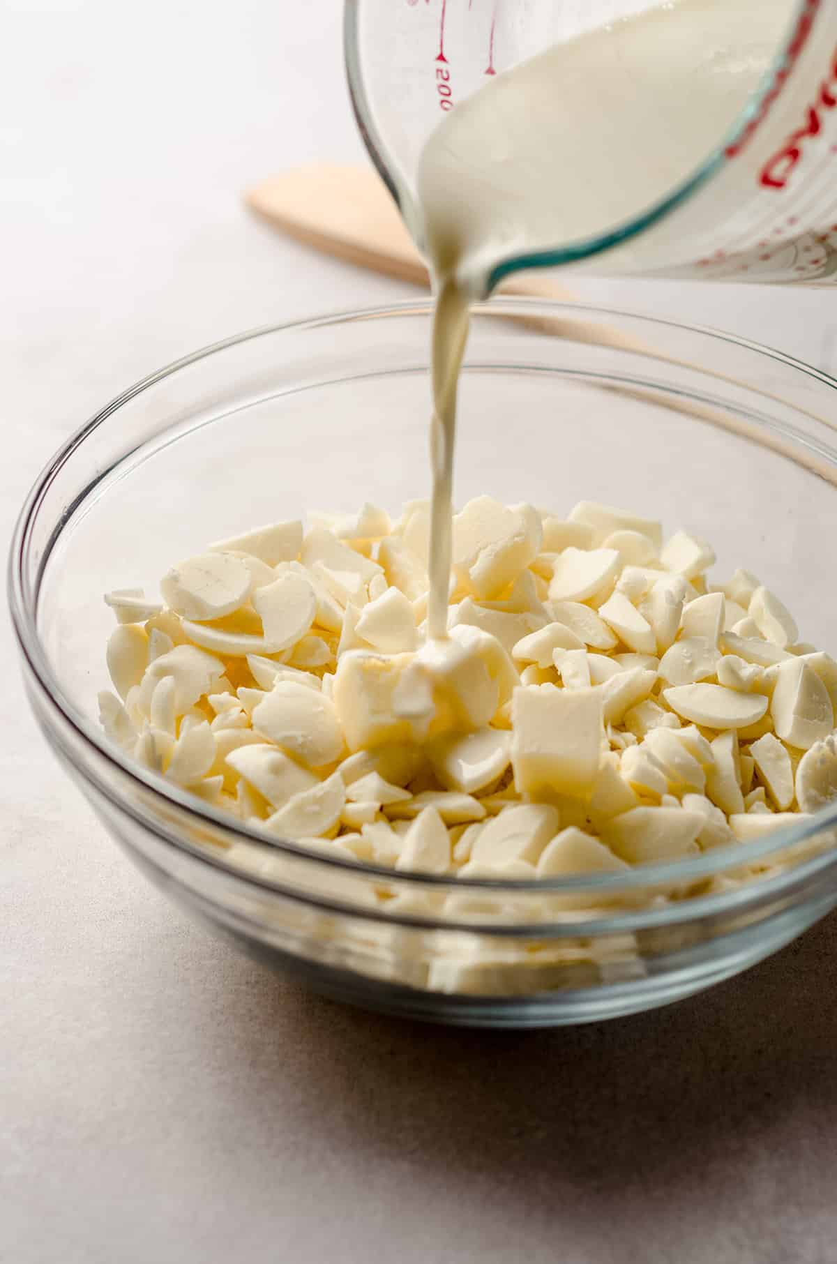 pouring hot cream onto white chocolate to make ganache