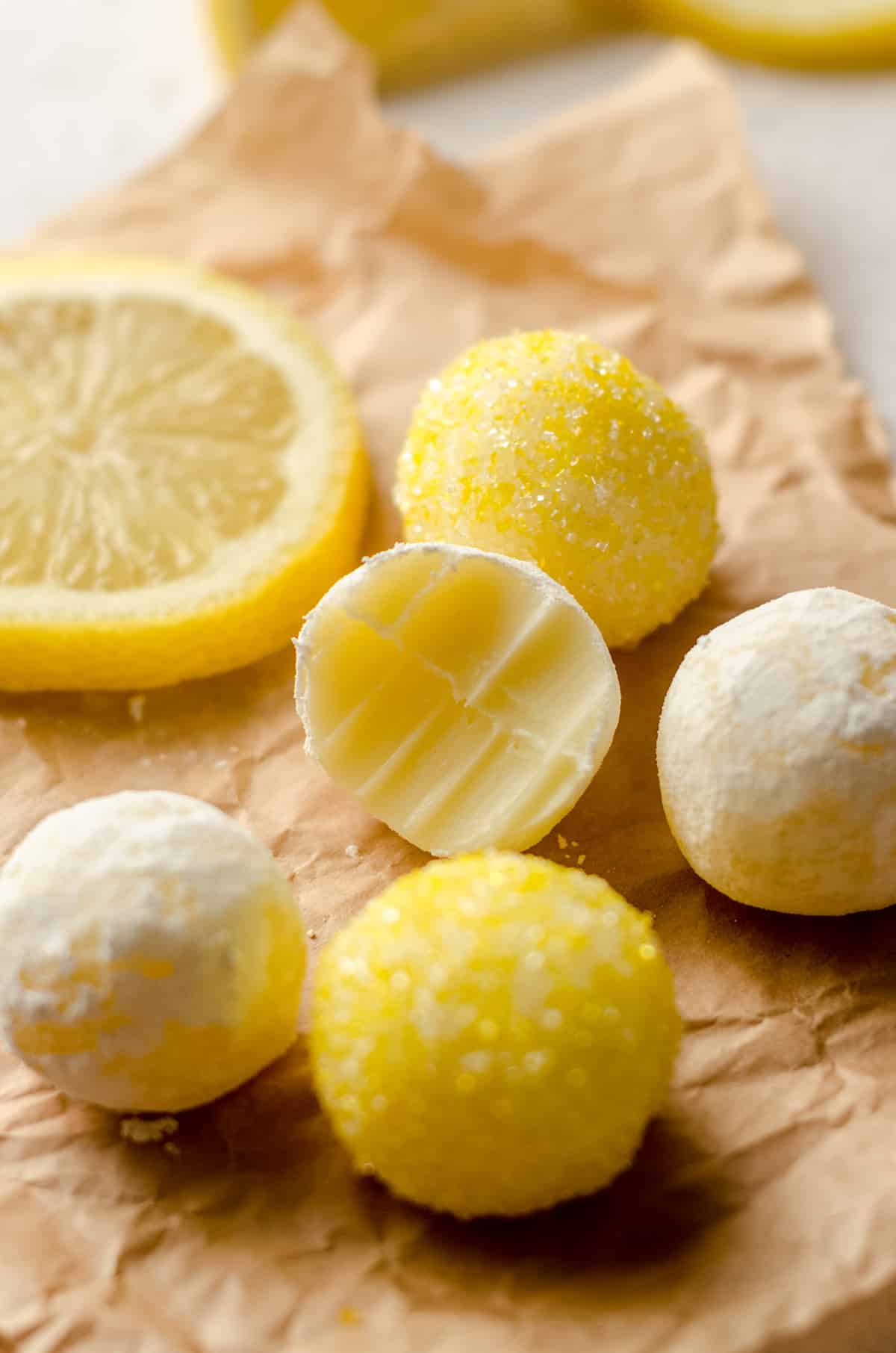 lemon truffles on parchment and one has a bite taken out of it