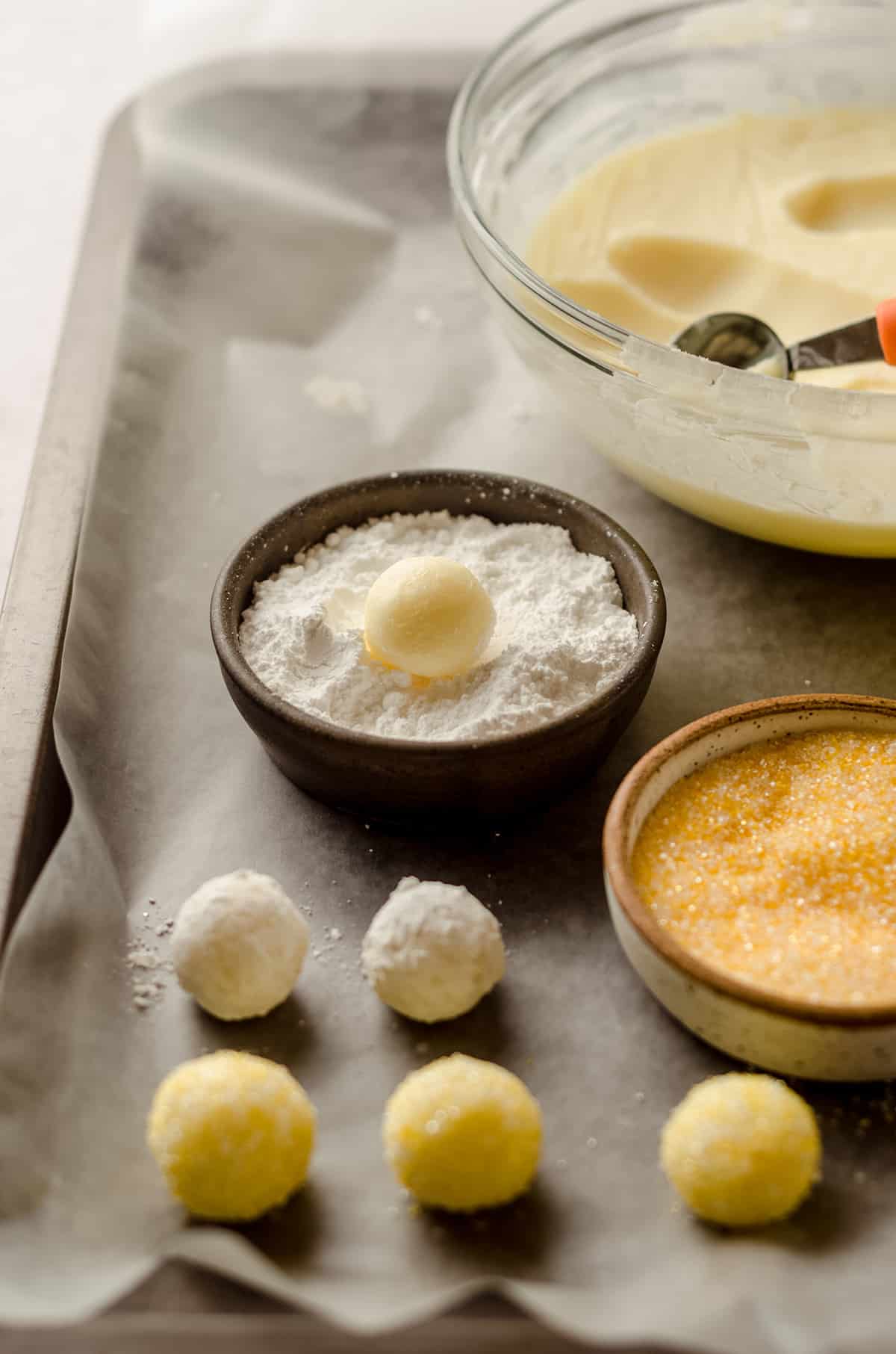 lemon truffles being rolled in powdered sugar