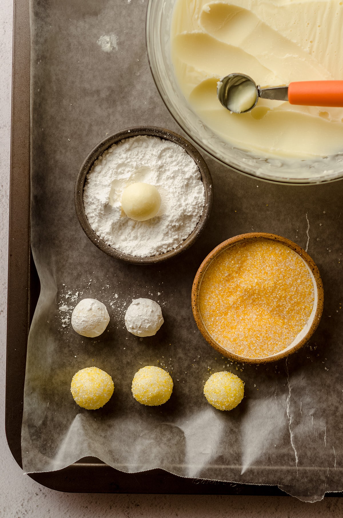 lemon truffles being rolled in powdered sugar