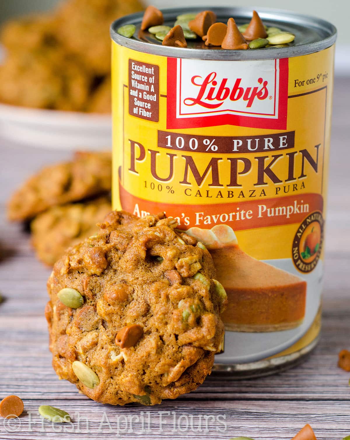 Pumpkin oatmeal cookie standing upright and resting on a can of pumpkin.