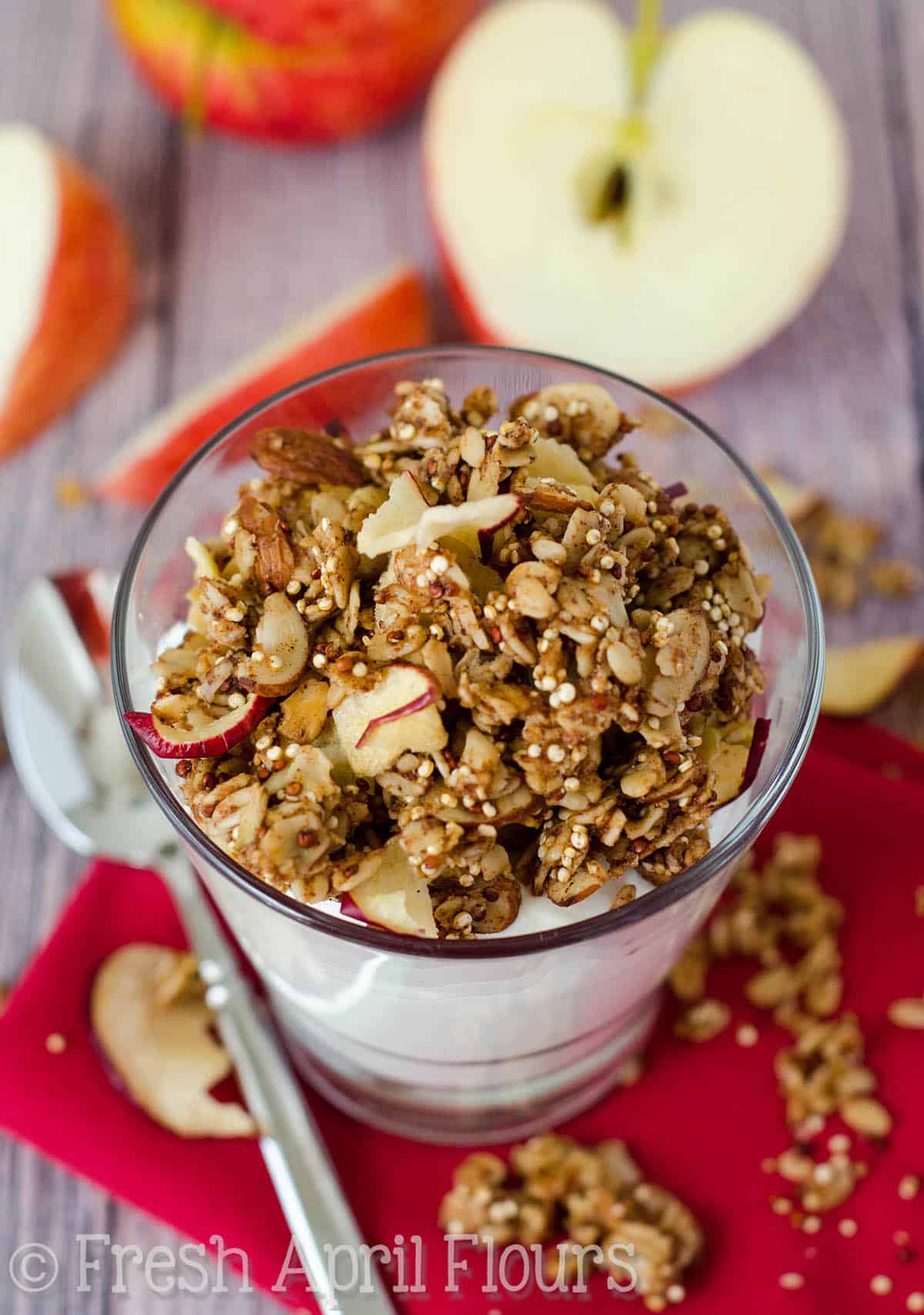 Apple quinoa granola on top of a cup of yogurt.
