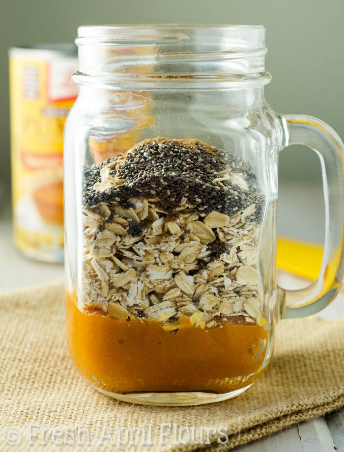 Ingredients for pumpkin overnight oats layered in a mason jar.