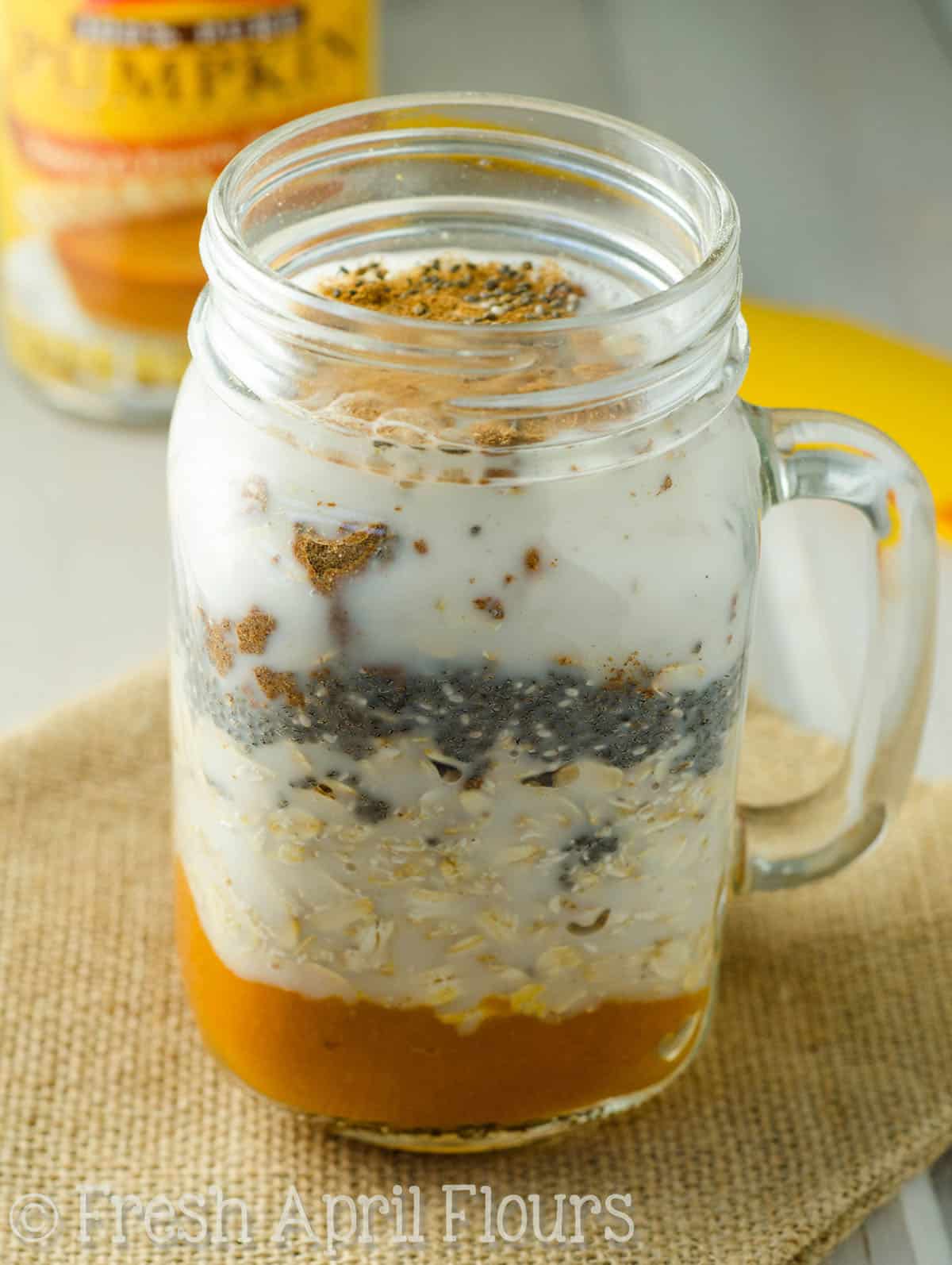 Ingredients for pumpkin overnight oats layered in a mason jar.