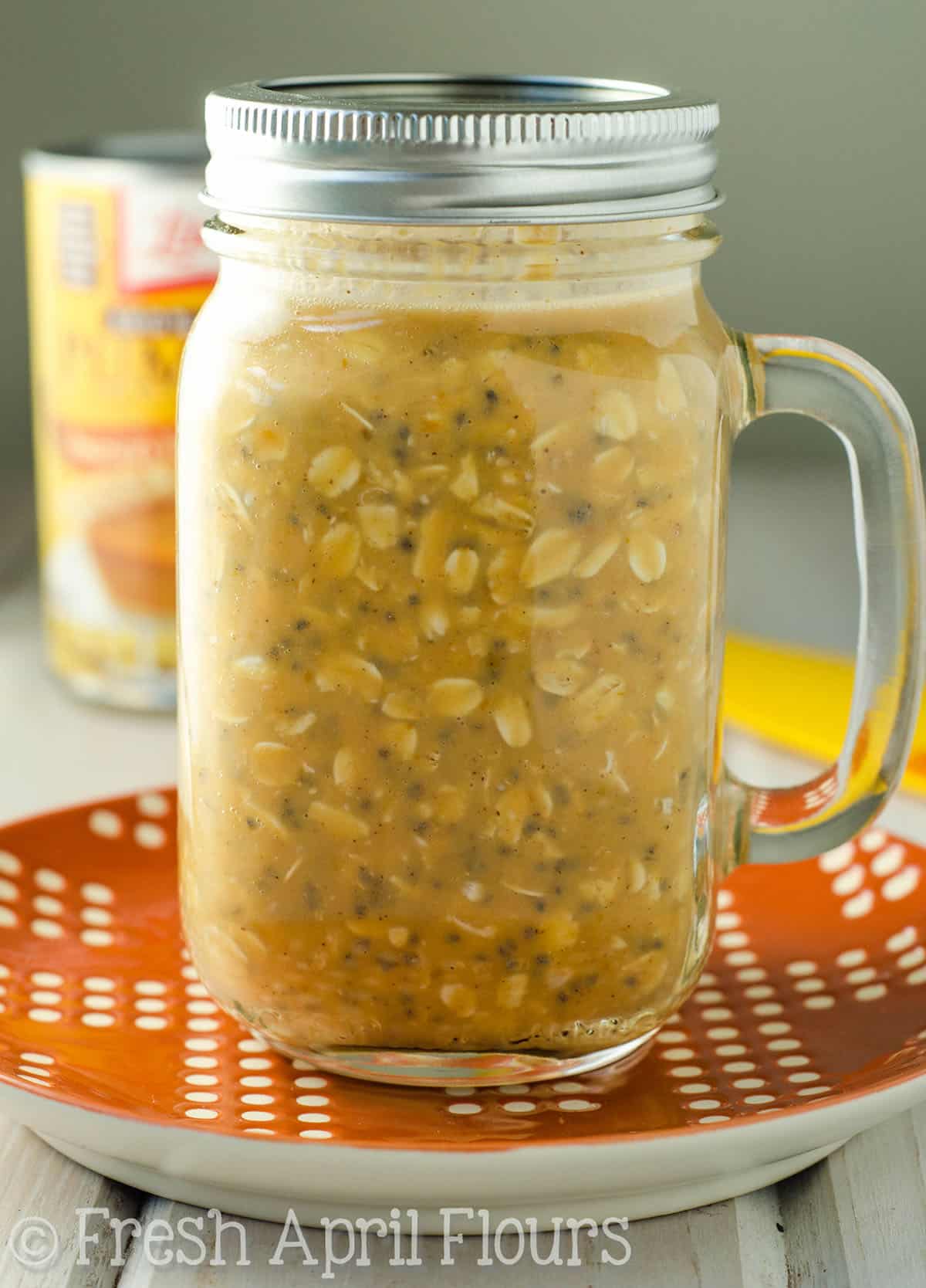 Pumpkin overnight oats in a jar sitting on a plate.