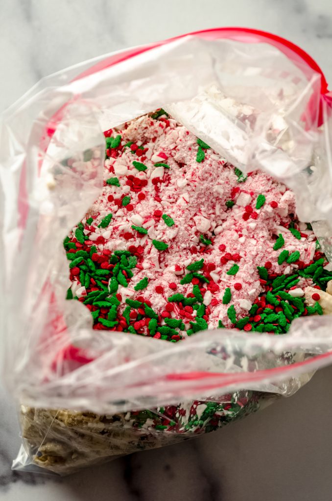 White chocolate-coated rice cereal with bits of candy cane and festive sprinkles on it.