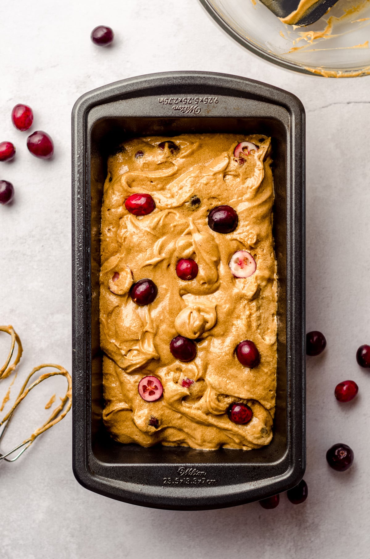 cranberry gingerbread batter in a loaf pan