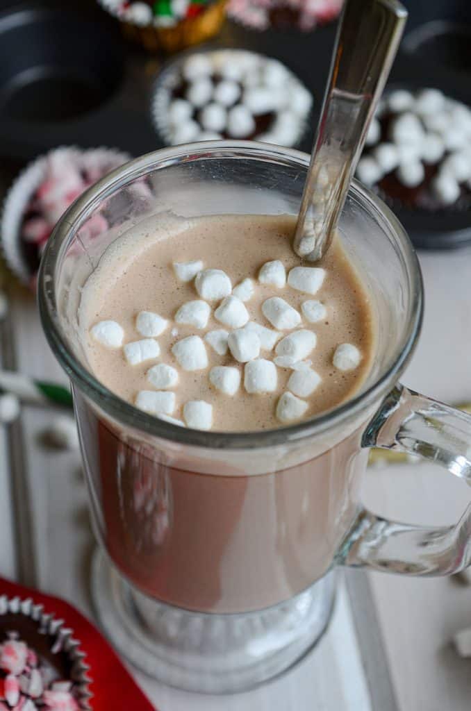 hot chocolate in a mug with a spoon and little mini marshmallows floating on top