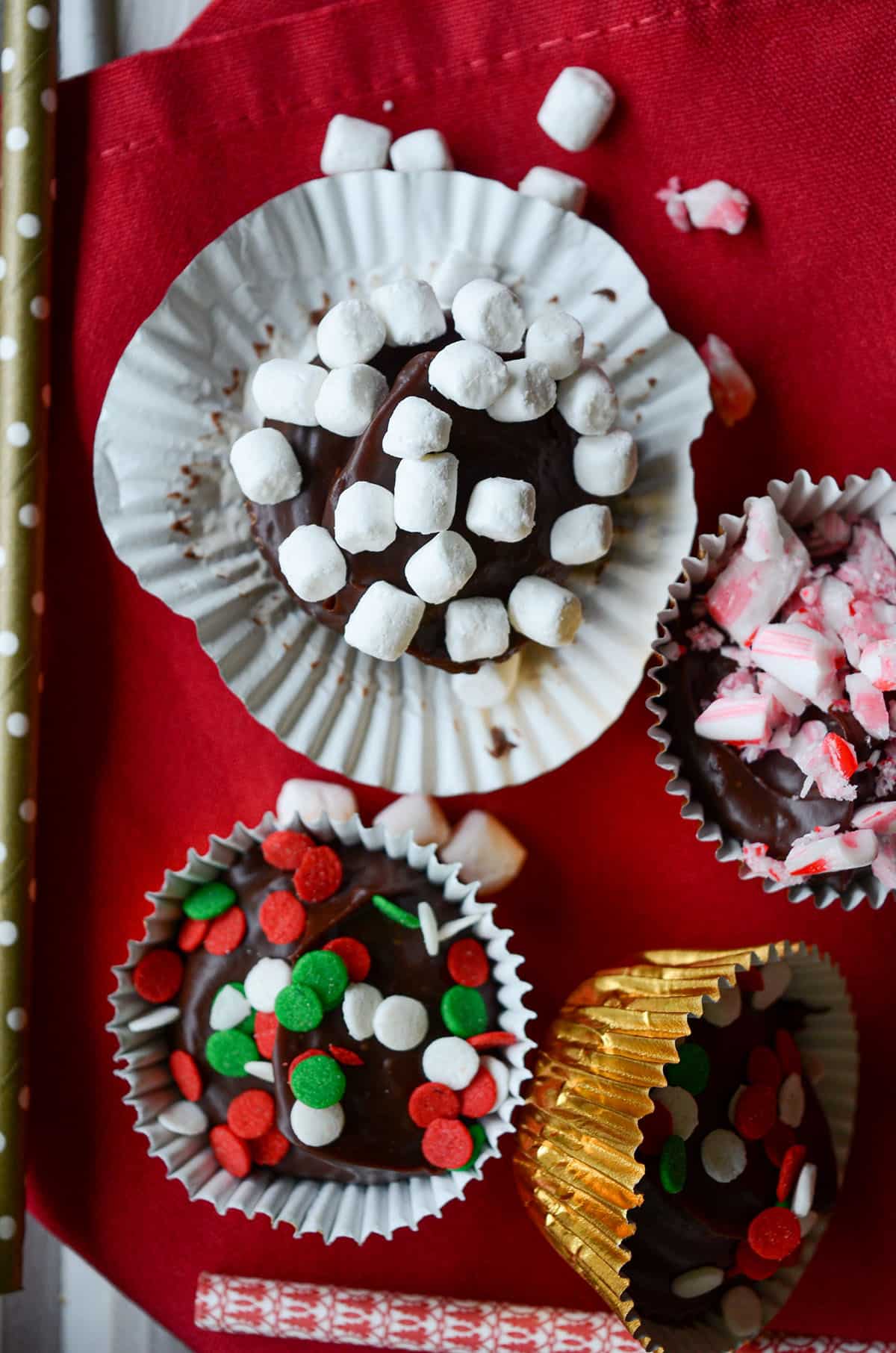 aerial view of hot chocolate bombs-- some have marshmallows, some have crushed candy canes, and some have christmas sprinkles