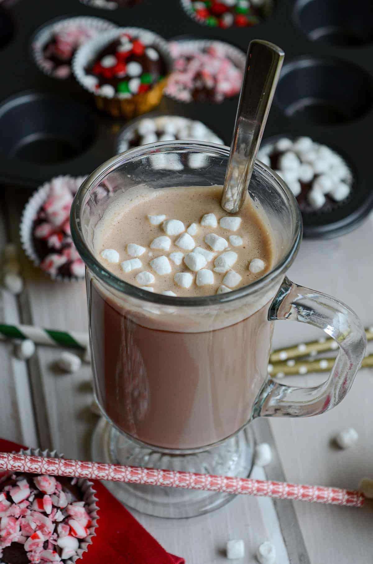 hot chocolate in a mug with a spoon and little mini marshmallows floating on top