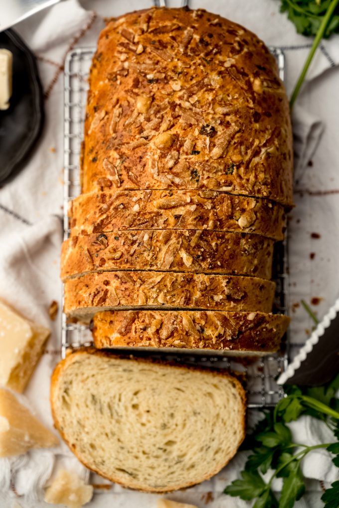 Aerial photo of a loaf of Parmesan parsley bread that has been sliced.