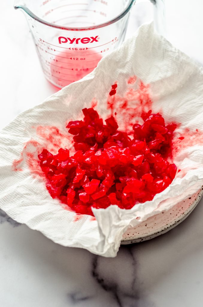 Chopped maraschino cherries on a paper towel. They have been squeezed to reduce the amount of moisture in them.