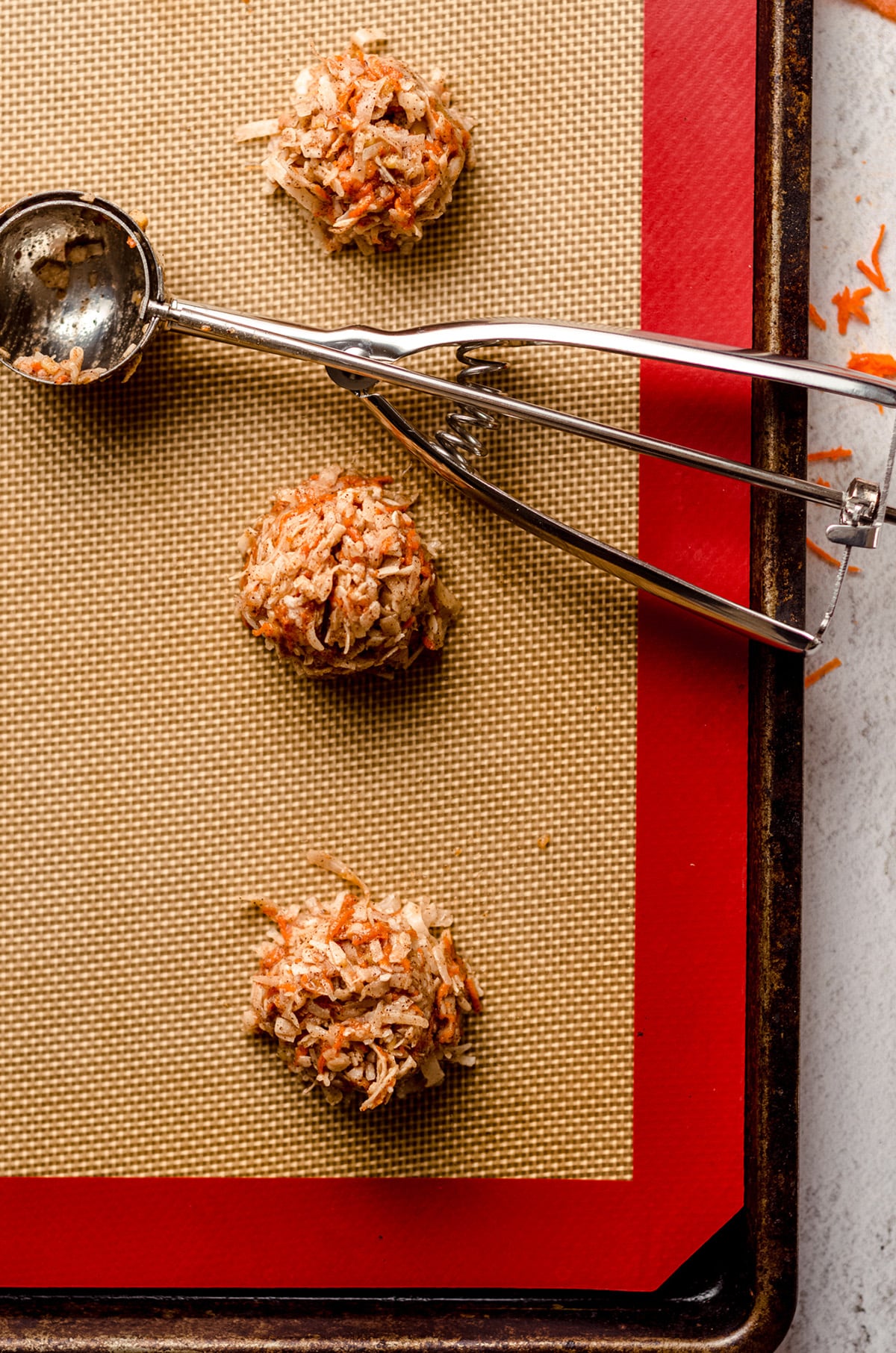 mounds of carrot cake macaroon batter on a baking sheet