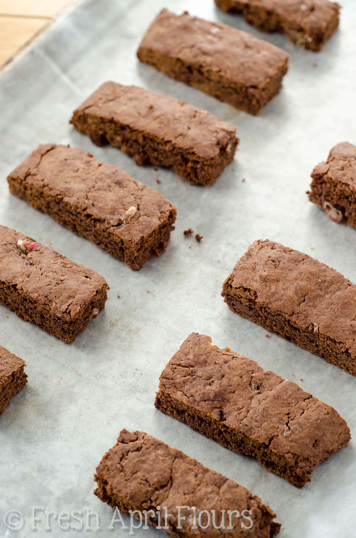 Baked chocolate peppermint biscotti on a baking sheet lined with parchment paper.