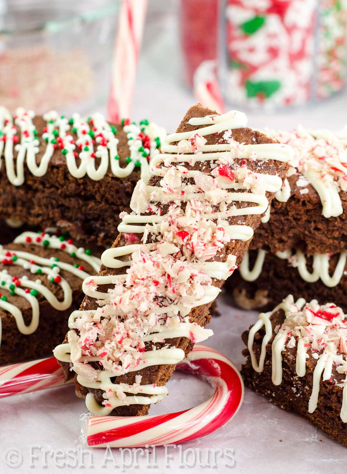 Chocolate peppermint biscotti leaning on a stack of more peppermint biscotti.