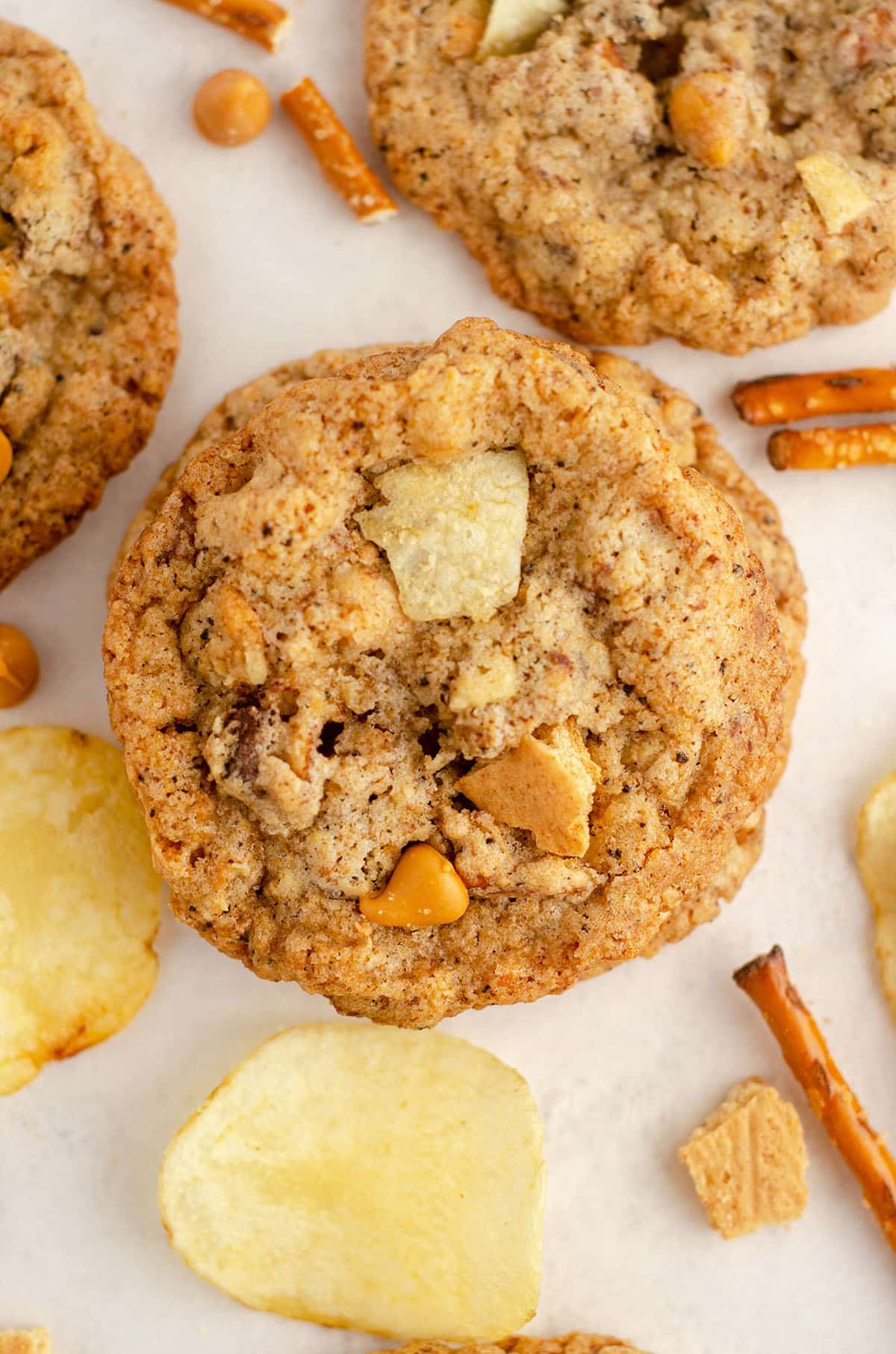 aerial photo of compost cookie scattered with pretzels, chips, butterscotch chips, chocolate chips, and graham cracker pieces