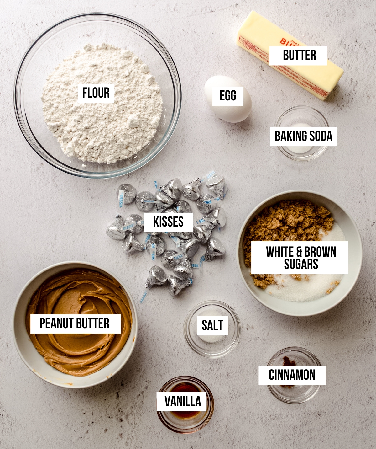 Aerial photo of ingredients to make peanut butter blossoms with text overlay labeling each ingredient.