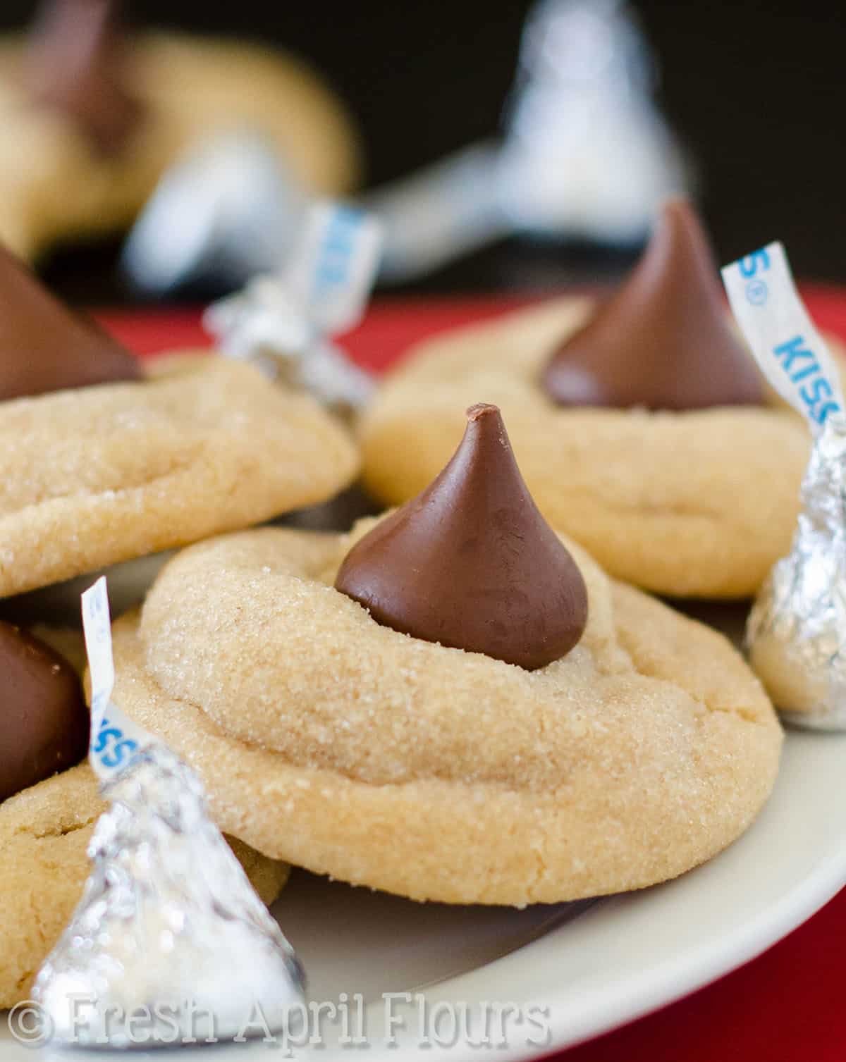 Peanut butter blossom cookies on a plate with Hershey's kisses.