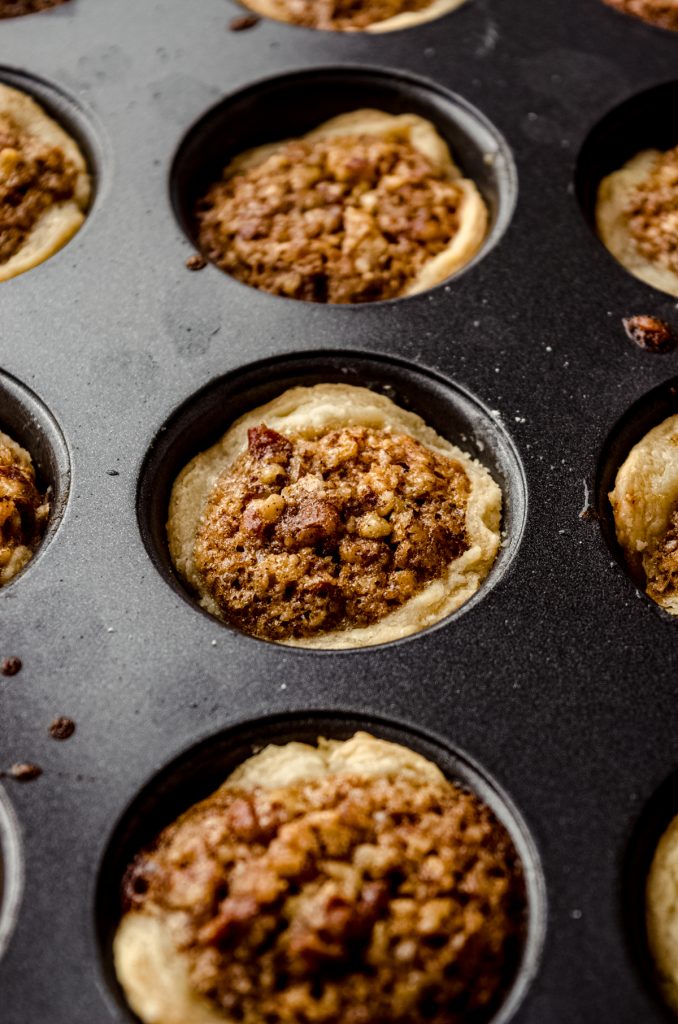 Pecan pie tarts in a baking pan.