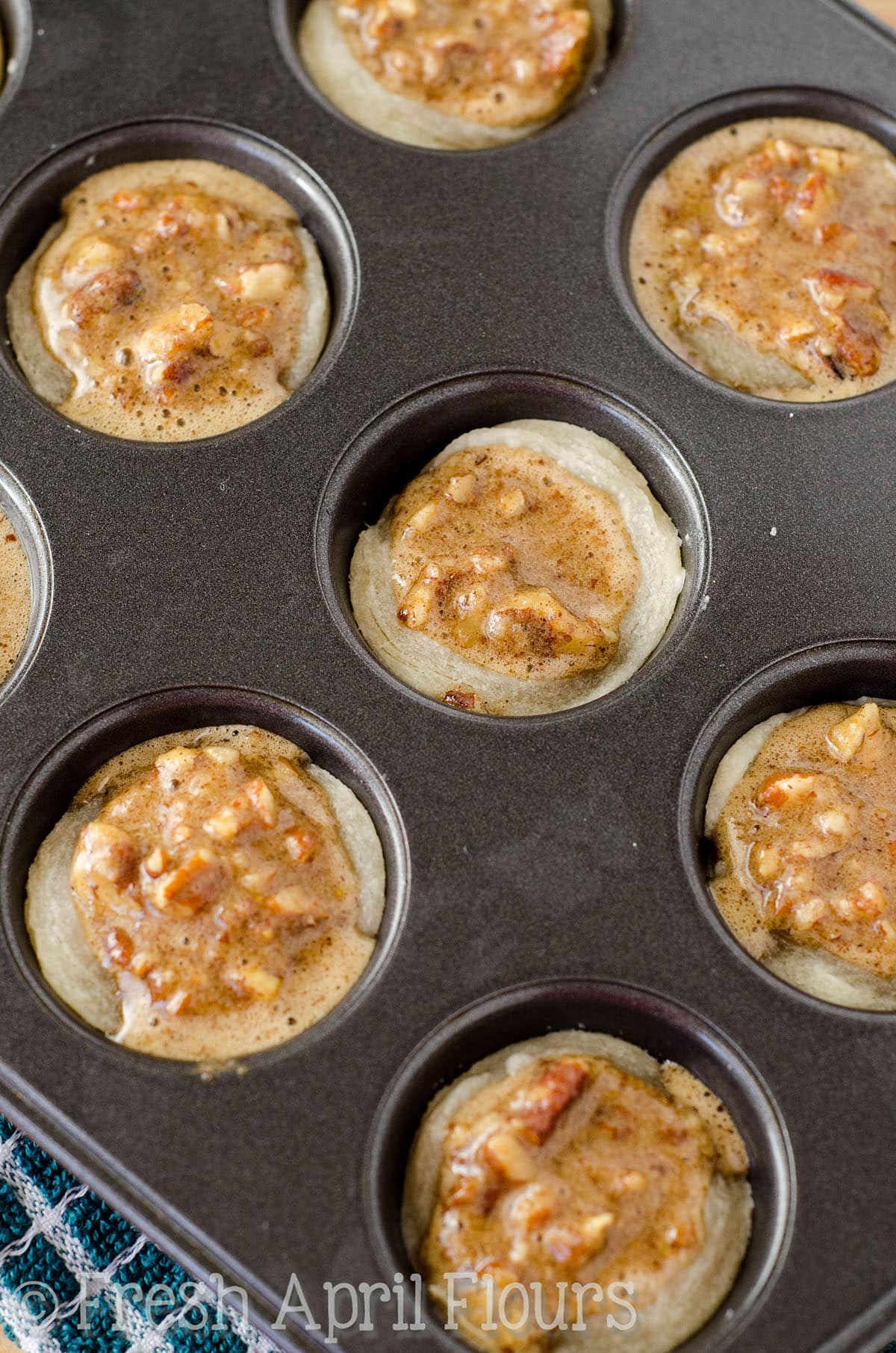 Pecan pie tart filling in mini cupcake wells lined with pie crust.