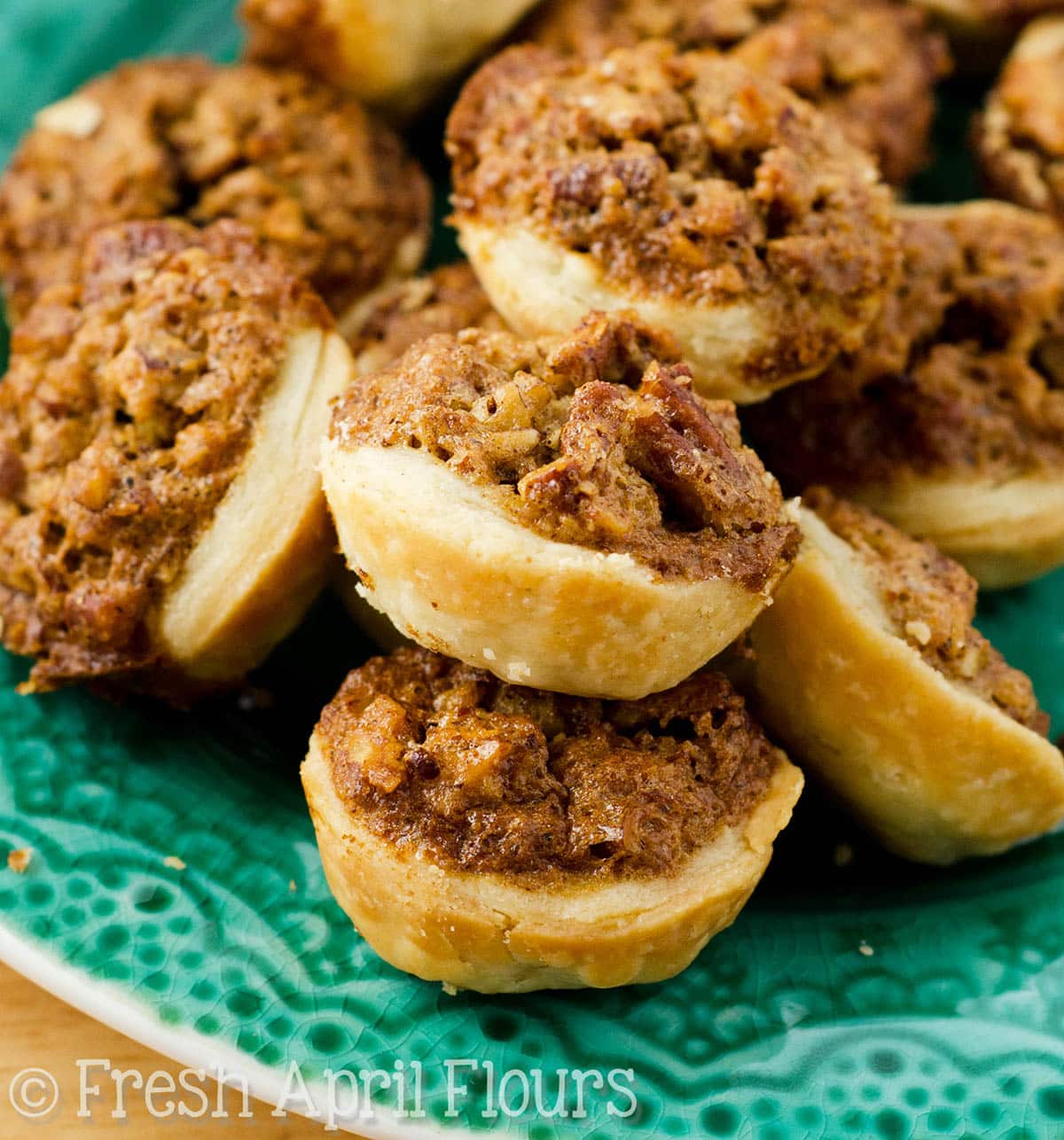 Pecan pie tarts on a turquoise plate.