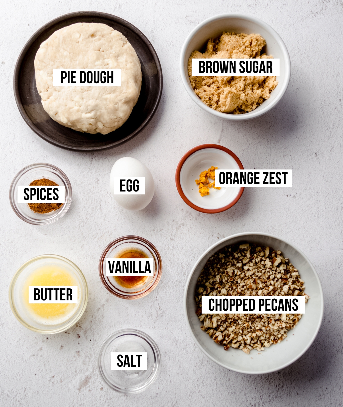 Aerial photo of ingredients to make pecan pie tarts with text overlay labeling each ingredient.