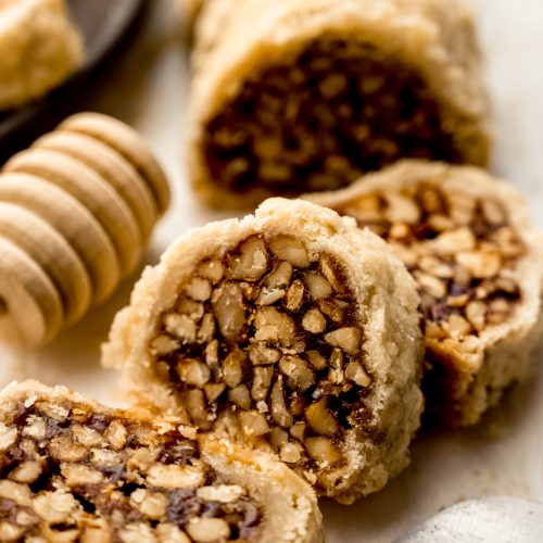 Honey walnut cookie stick slices (sfratti) on a surface.