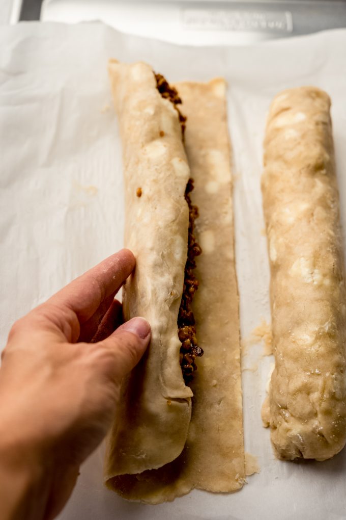 Someone is rolling up a honey walnut cookie stick.