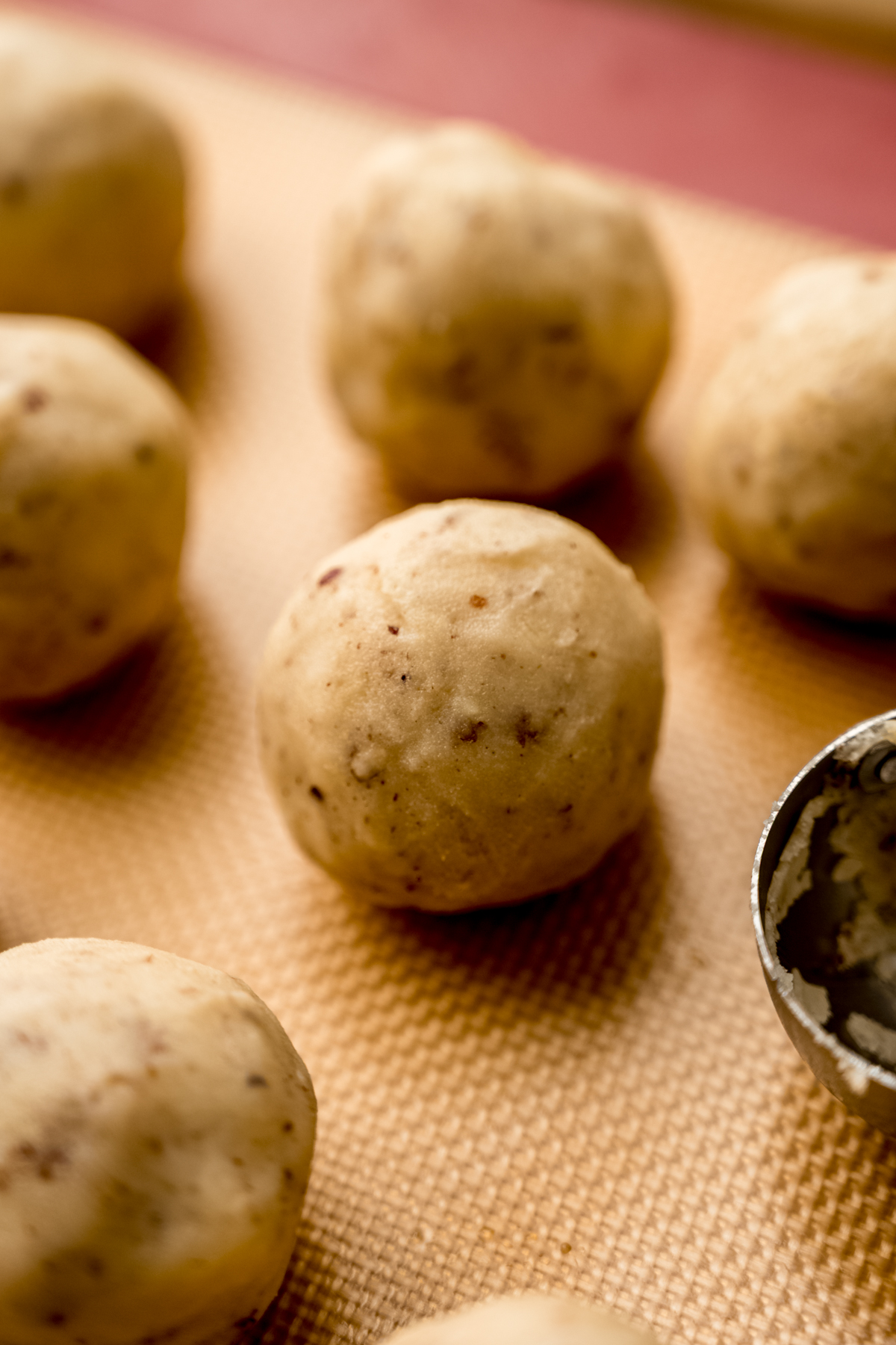 A ball of Russian tea cake cookie dough on a baking sheet.