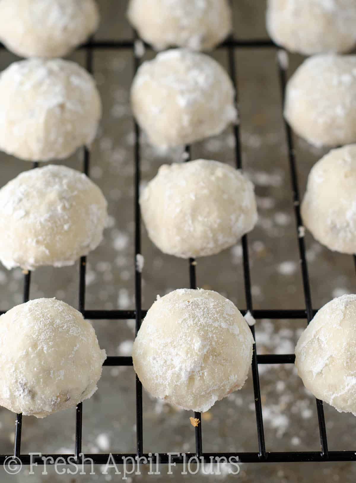 russian tea cakes on a wire cooling rack ready to get rolled in powdered sugar
