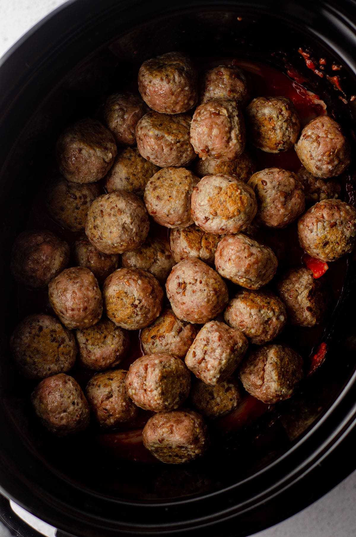 aerial photo of browned gluten free meatballs in a slow cooker ready to cook