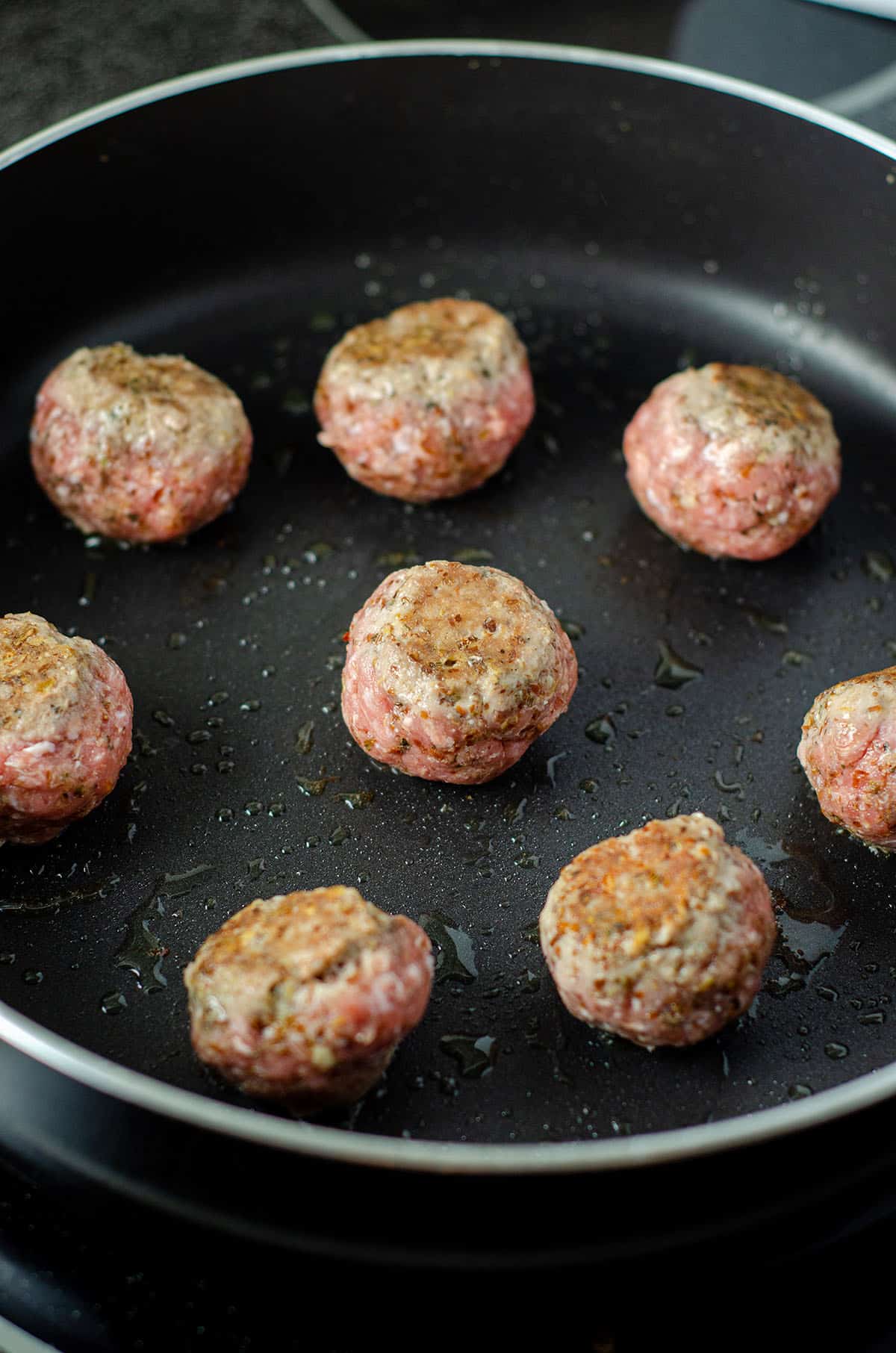 meatballs browning in a skillet