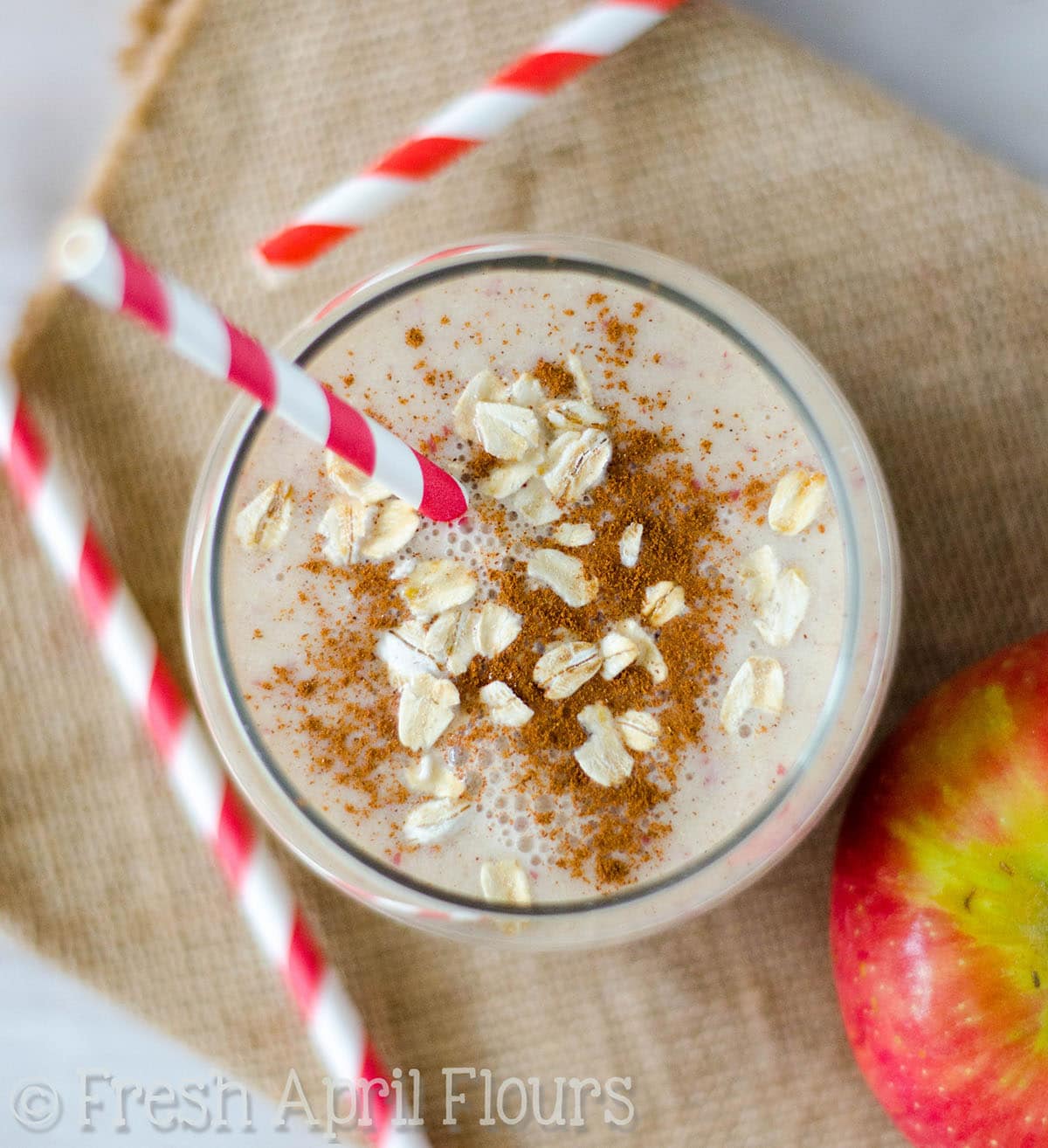 Aerial photo of an apple pie smoothie with a straw in it.