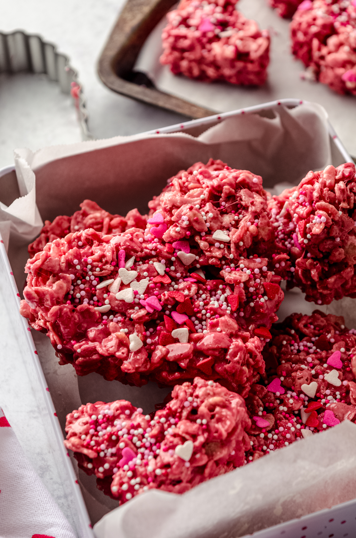 Heart-shaped red velvet Rice Krispie treats in a treat box.