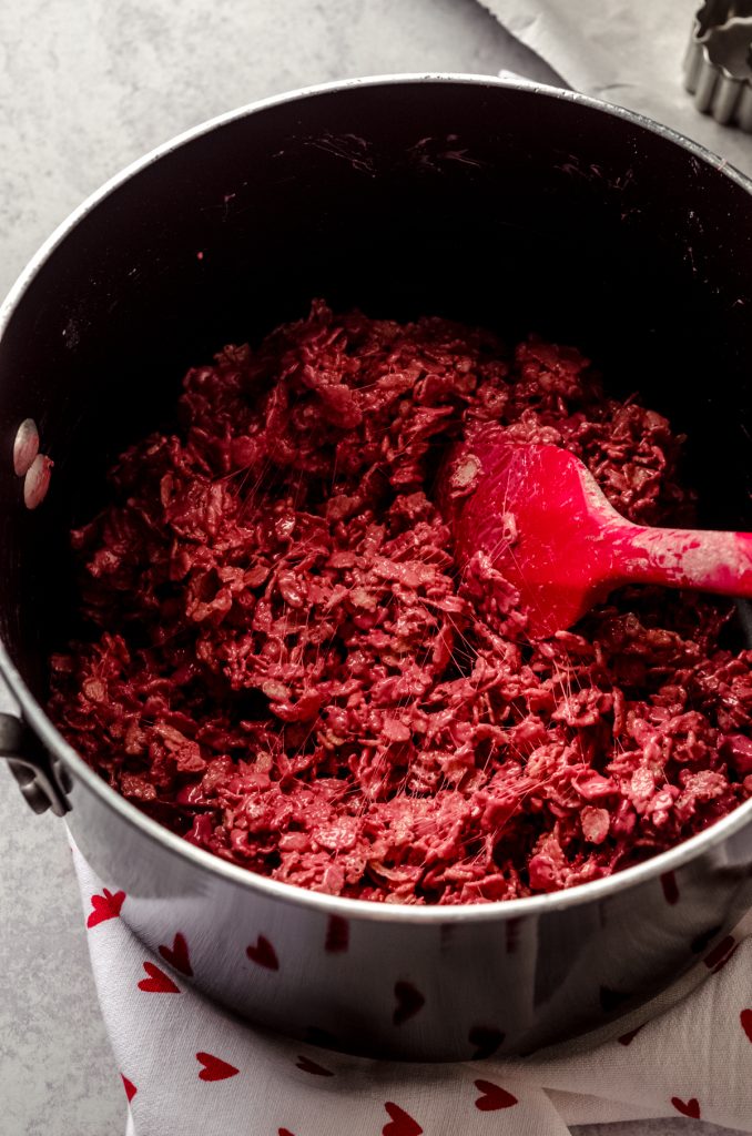 Ingredients for red velvet Rice Krispies treats in a large saucepan.