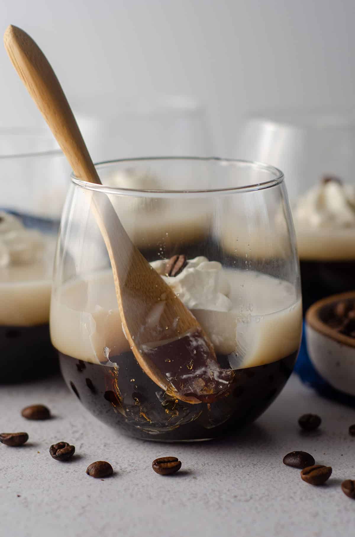 coffee jello with a wooden spoon in it with a scoop taken out