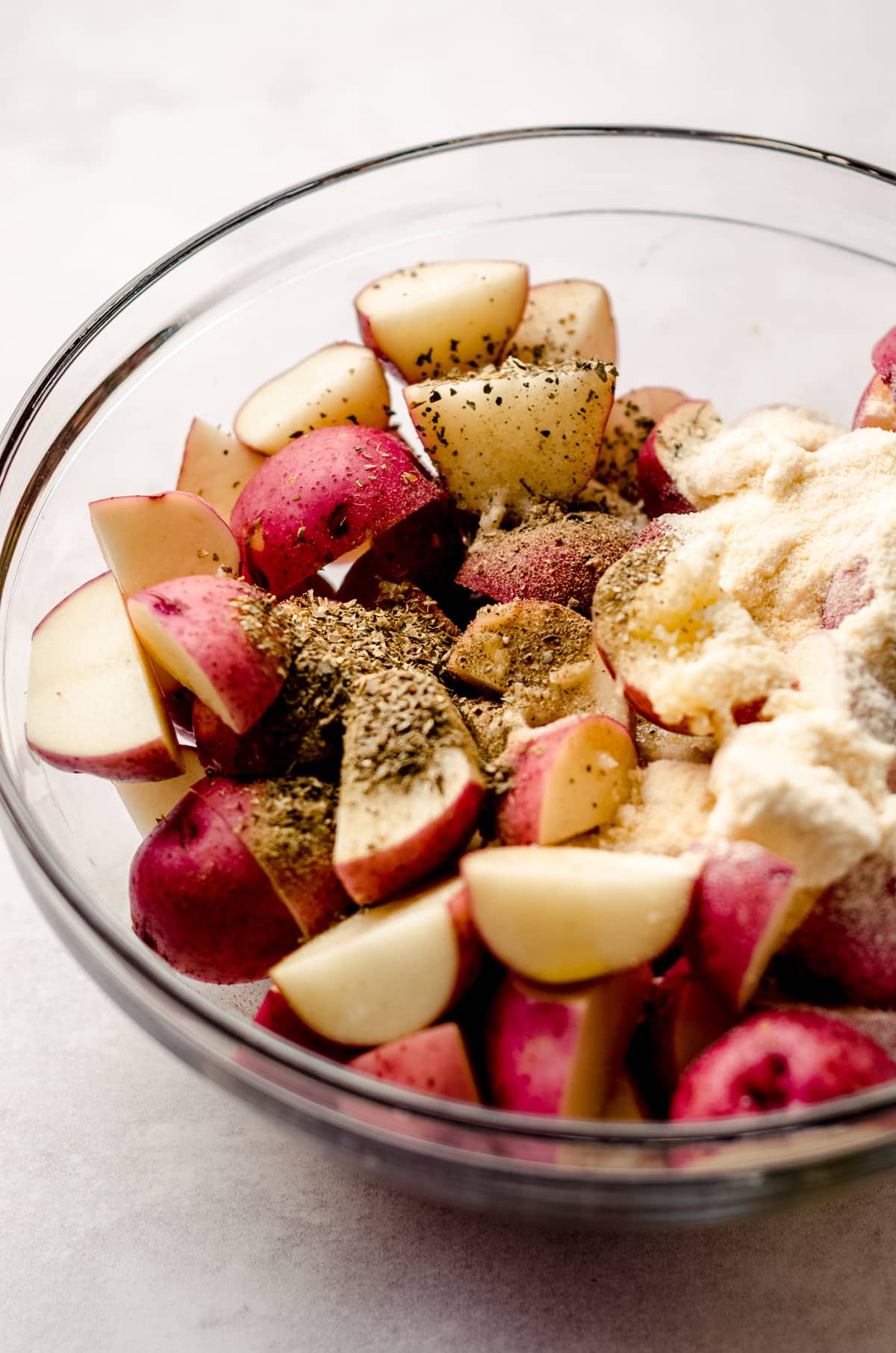 red potatoes and spices in a glass bowl