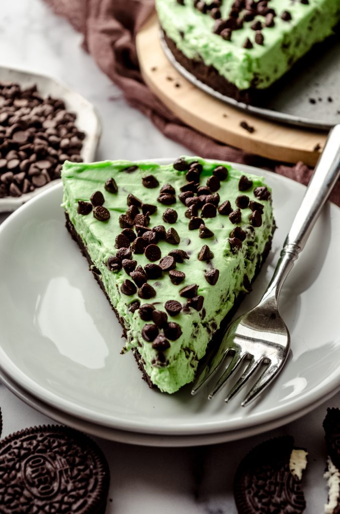 A slice of no bake mint chocolate chip pie on a plate with a fork.