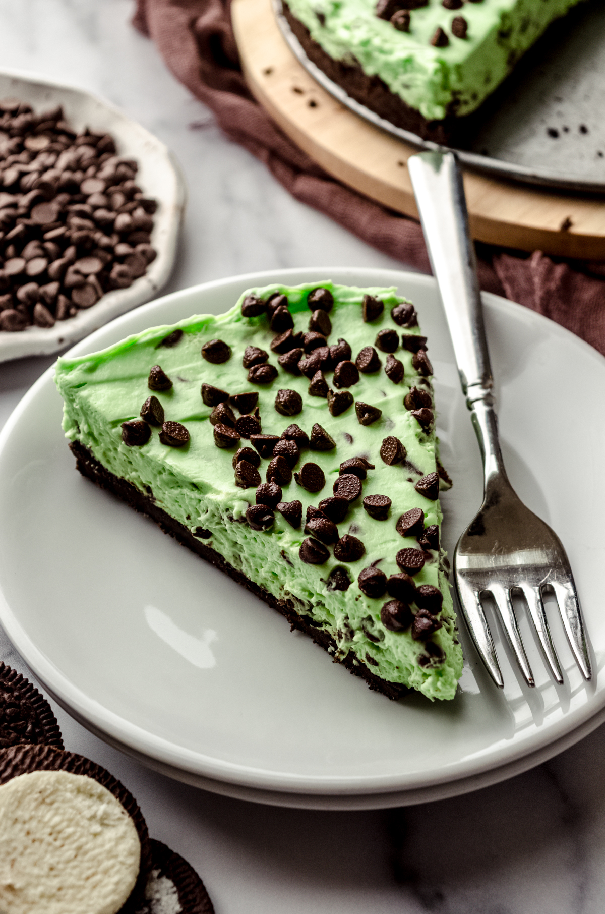 A slice of no bake mint chocolate chip pie on a plate with a fork.