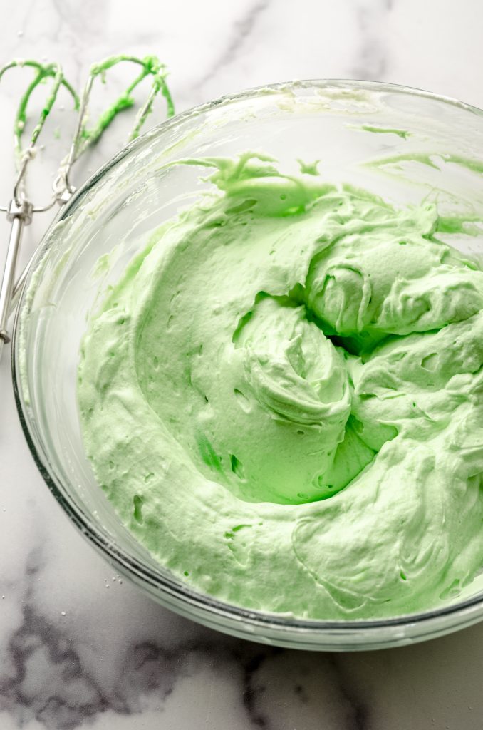 A bowl of the filling for no bake mint chocolate chip pie with a spatula.