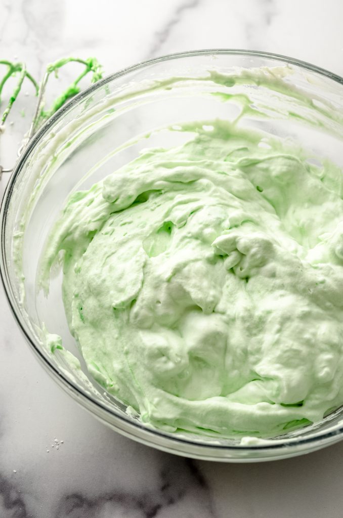 A bowl of the filling for no bake mint chocolate chip pie with a spatula.