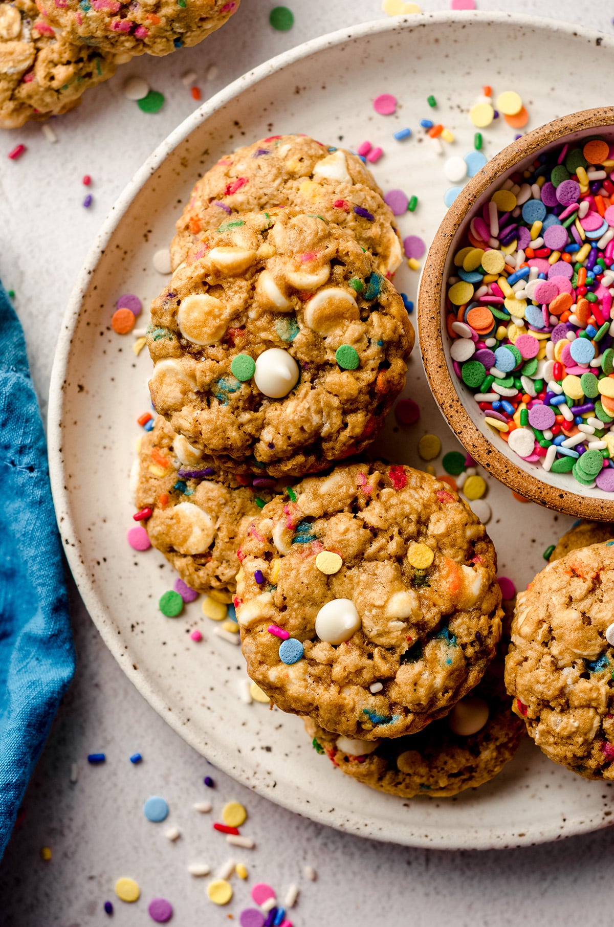 aerial photo of funfetti oatmeal cookies on a plate with a bowl of sprinkles