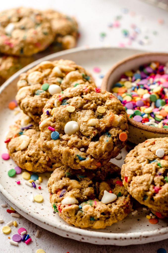 funfetti oatmeal cookies on a plate with a bowl of sprinkles