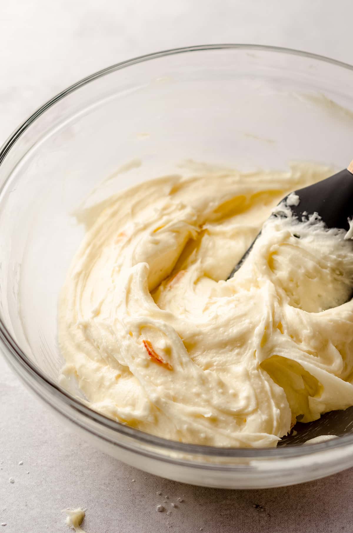 orange cream cheese frosting in a glass bowl