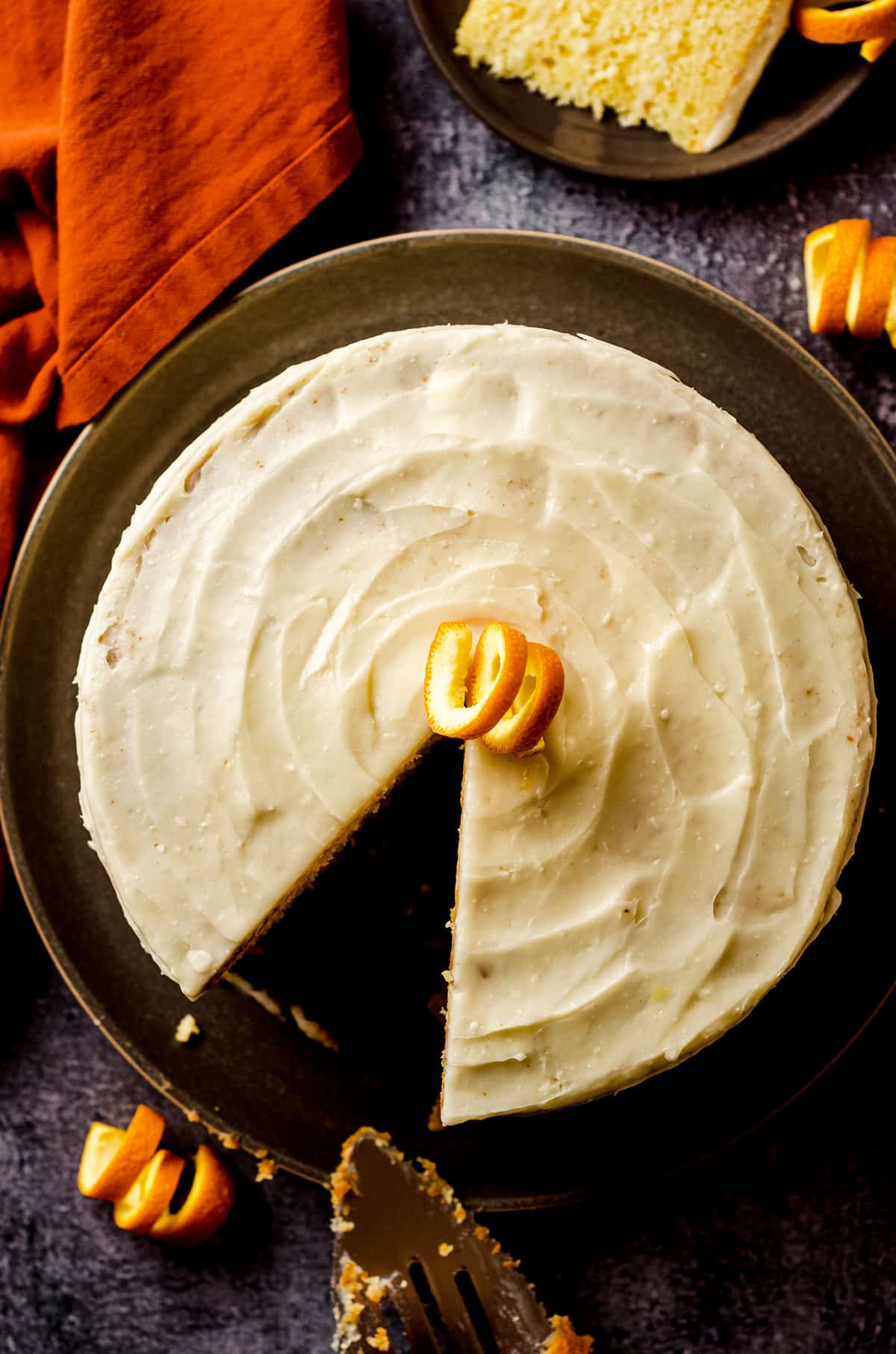 aerial photo of orange creamsicle layer cake with a slice taken out of it