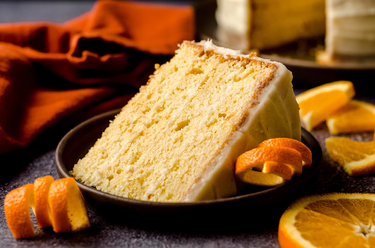 slice of orange creamsicle layer cake on a plate